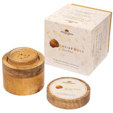 The Caviar Gold Face Pack open in its mango-wood vessel beside its box, caviar pearls visible in the golden texture