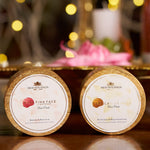 Engraved lids of the Rose Pink Face Tightener and The Caviar Gold Face Pack against warm candlelight